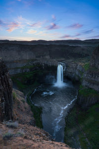 Scenic view of waterfall against sky