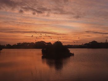 Scenic view of lake against orange sky