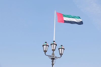Low angle view of uae flag against blue sky