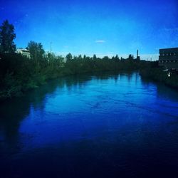 Scenic shot of calm river with buildings in background