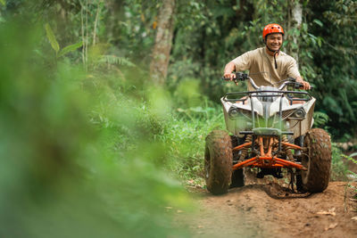 Side view of man standing in forest