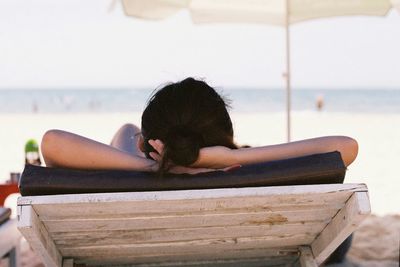 Rear view of woman sitting on bench