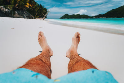 Low section of person relaxing on beach