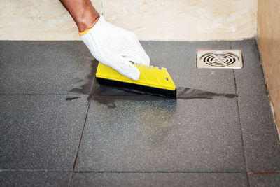 Midsection of man working on tiled floor