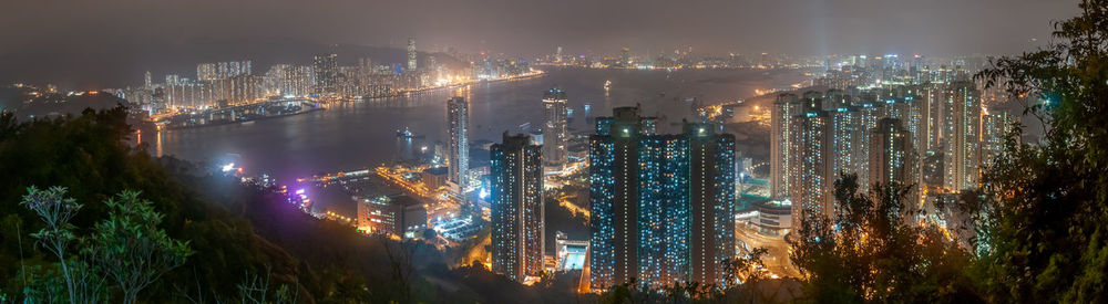 High angle view of illuminated buildings against sky at night