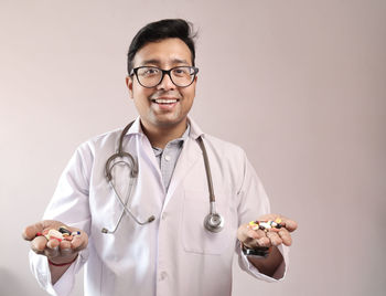 Portrait of smiling young man holding eyeglasses