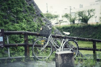 Bicycle parked by fence on field