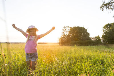 Full length of a smiling girl on field