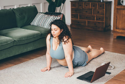 Young woman sitting on sofa at home