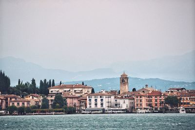 Buildings at waterfront against sky