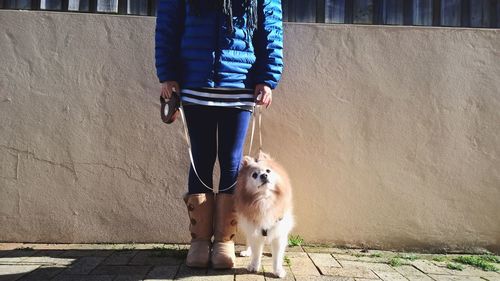 Woman standing with dog on street