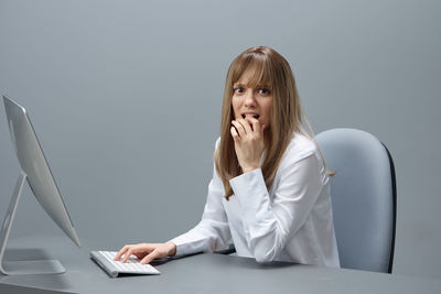 Young woman using mobile phone while sitting at home