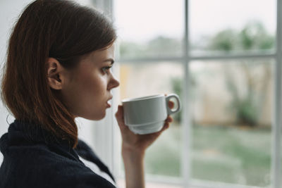 Portrait of young woman drinking coffee