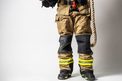 Low section of man standing against white background