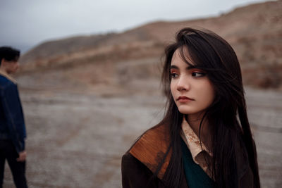 Portrait of a beautiful woman standing on beach