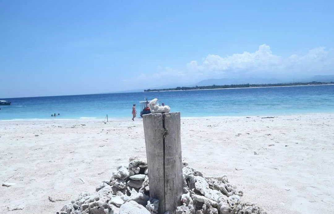 sea, beach, sky, water, land, horizon over water, horizon, beauty in nature, scenics - nature, nature, day, tranquility, real people, tranquil scene, sand, non-urban scene, leisure activity, idyllic, blue, outdoors, wooden post