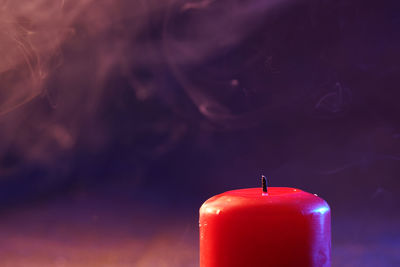 Close-up of lit candle on table