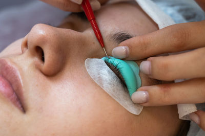 Cropped hand of beautician treating customer at spa