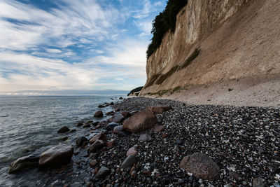 Close-up of pebbles on beach against sky