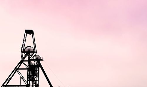 Low angle view of silhouette crane against sky during sunset