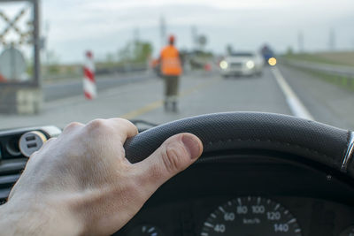 Cropped hand of man driving car