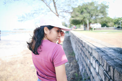 Girl looking away while standing on land