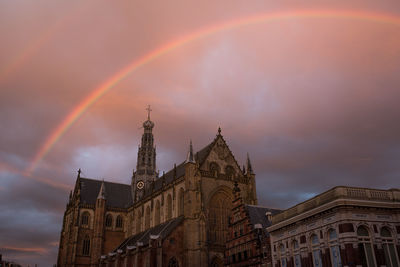 Low angle view of rainbow over city against sky