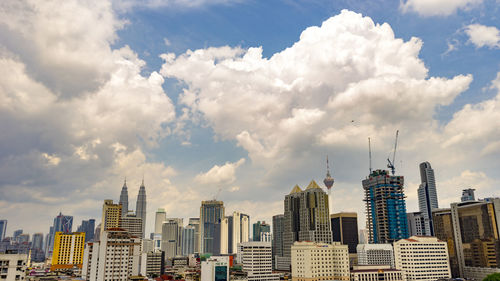 View of cityscape against cloudy sky