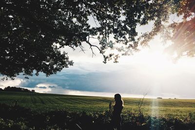 Woman standing on field against sky