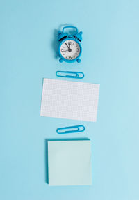 Close-up of clock on table against blue background