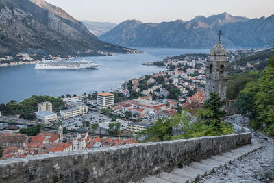 Townscape by sea against mountains in town