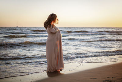 Young pregnant woman with a beautiful sea view on the background. happy and calm pregnant woman 