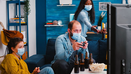 People wearing mask playing game at home