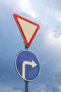 Low angle view of road sign against sky