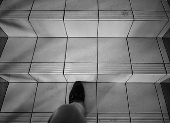 Low section of woman standing on tiled floor