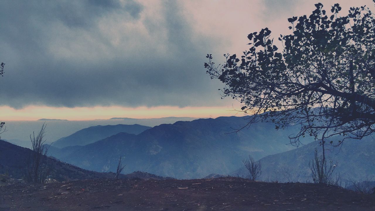 tranquil scene, tranquility, sky, scenics, mountain, beauty in nature, landscape, cloud - sky, nature, mountain range, cloudy, non-urban scene, tree, weather, cloud, idyllic, bare tree, remote, sunset, silhouette