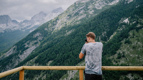 Rear view of man photographing mountains