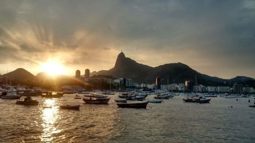 Boats in sea at sunset