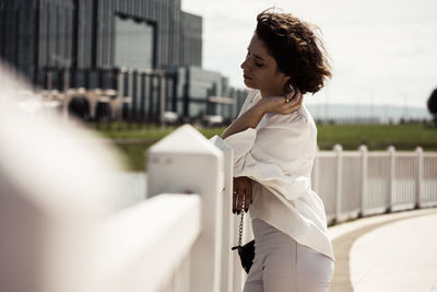 Side view of young woman standing outdoors