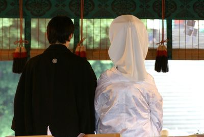 Rear view of japanese newlywed couple sitting at home