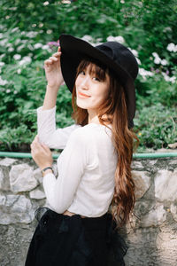 Portrait of smiling young woman wearing hat