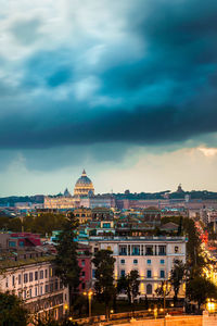 Buildings in city against cloudy sky