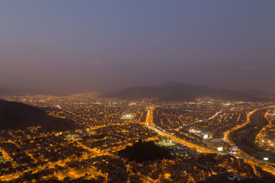 High angle view of illuminated cityscape against sky at night