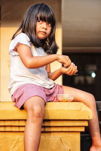 Young woman using mobile phone while sitting on sofa at home