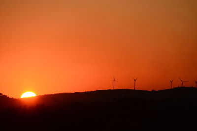 Scenic view of silhouette landscape against orange sky