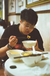 Young man eating food at restaurant