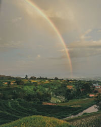 Scenic view of rainbow over landscape against sky