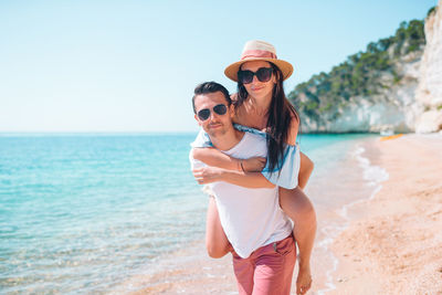 Portrait of couple piggybacking on beach