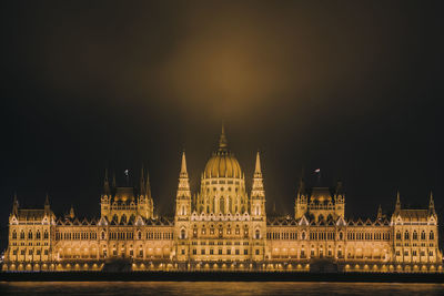 Illuminated city against sky at night