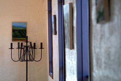 Candlestick holder against wall by window